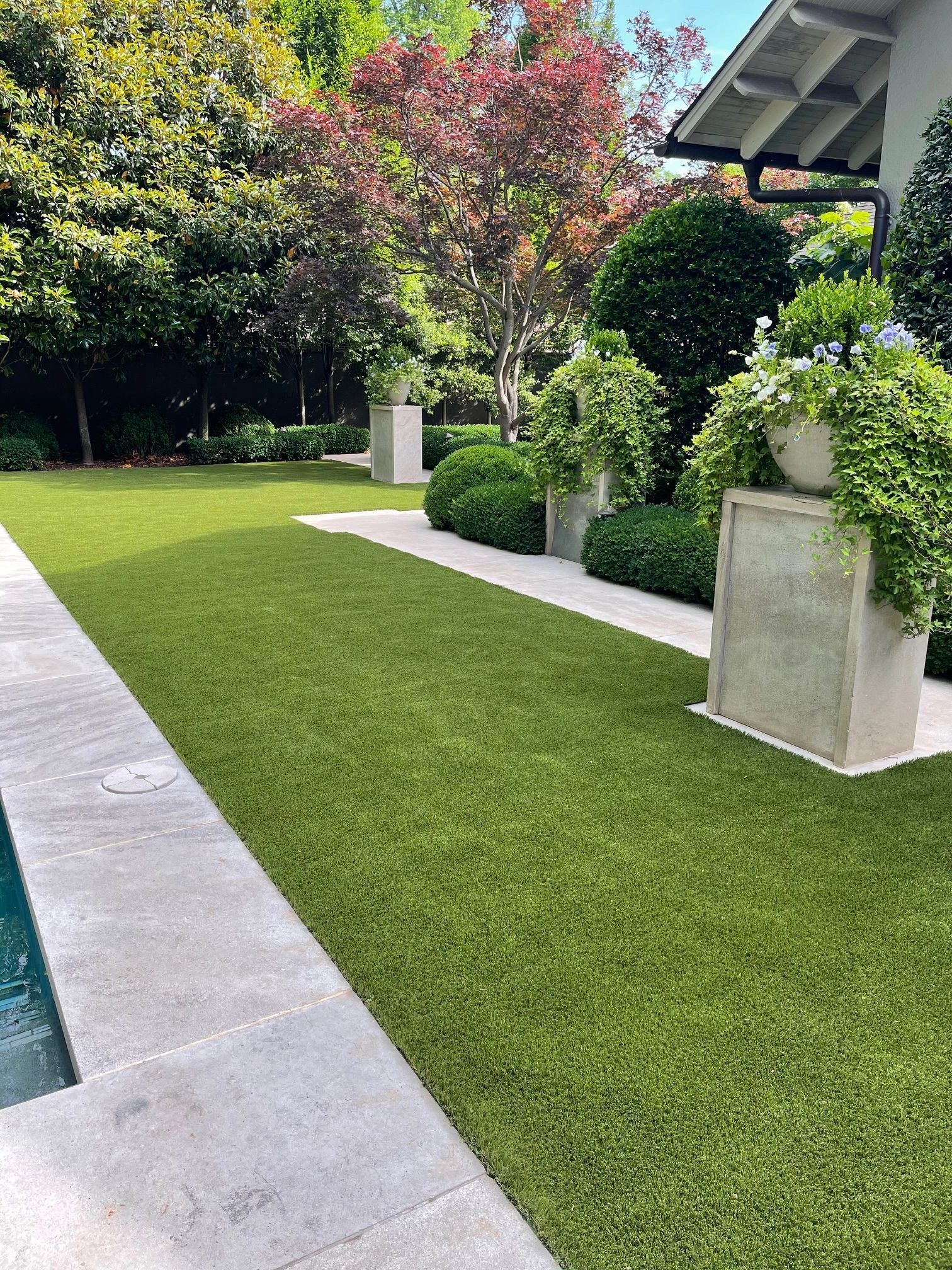 Lush side-yard lawn framed by clean bed lines